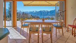 Ein Essbereich mit Tisch und Stühlen, einem Teleskop und Blick auf Berge.