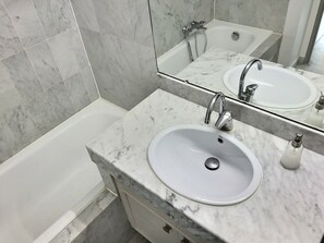A bathroom with a white sink, a mirror, and a bathtub. - Breathtaking views/standing/all on foot (Saint-Raphaël)