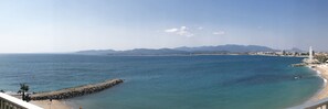 A coastal view with a clear sky, a rocky breakwater, and a distant mountain range. - Breathtaking views/standing/all on foot (Saint-Raphaël)