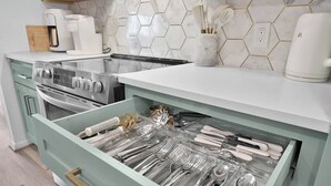 A kitchen with a drawer organizer filled with utensils, a coffee maker, and a stove. - Lakefront Getaway ☀️ Quiet Canal - Park Your Boat 🚤 4 Bed Townhouse by EverSan Cooper Getaways (Montgomery)