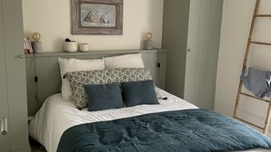 A neatly arranged bedroom with a bed, bedside tables, a wardrobe, and a painting on the wall. - Vacation home with jacuzzi 5 minutes from the beach (LE BOIS PLAGE EN RE)