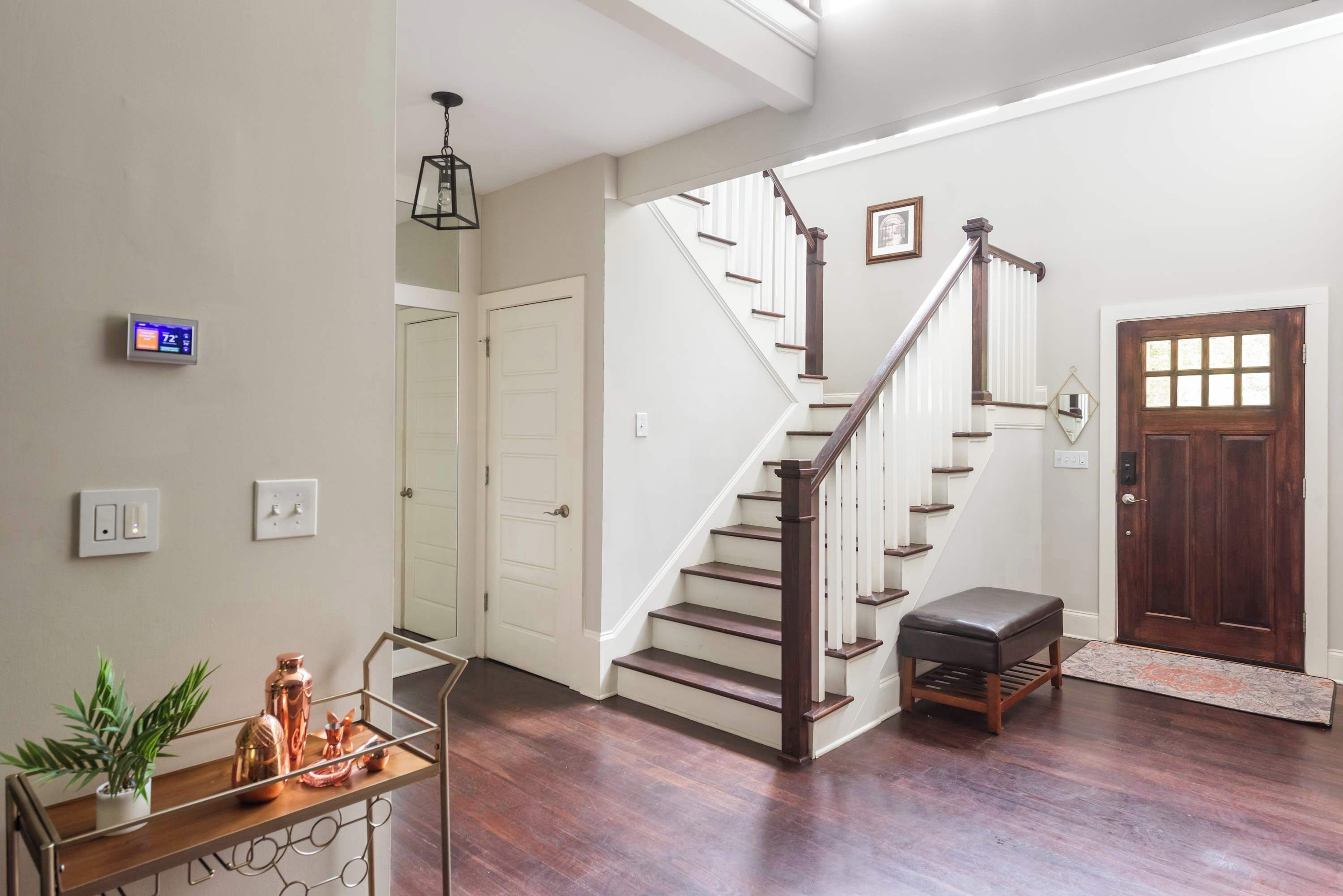 A staircase with wooden steps and a handrail, leading to a door with a window.