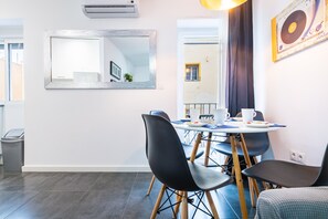 A dining area with a round table, black chairs, and a mirror on the wall. - Apartment Coral close to the Beach with Terraces & Wi-Fi (Vinaròs)