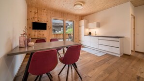 Una cocina moderna con armarios de madera, horno empotrado y televisor de pantalla plana sobre la encimera.
