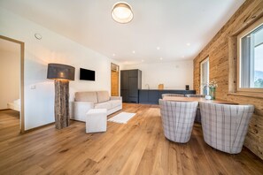 Un espace de vie moderne comprenant un canapé, une table basse et une table à manger avec des chaises.