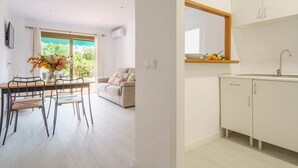 A modern kitchen with white cabinets, a built-in sink, and a window above the countertop. - Holiday Home "Yolima" near the Beach with Wi-Fi, Air Conditioning and Garden (Sóller)