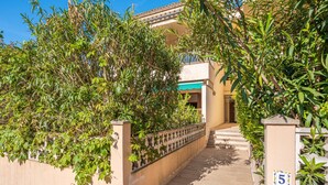 A pathway leading to a building with a beige facade, a number 5 sign, and lush greenery. - Holiday Home "Yolima" near the Beach with Wi-Fi, Air Conditioning and Garden (Sóller)