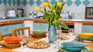 A dining table with a vase of yellow tulips, various dishes, and glasses. - Apartment "Dimora Teatro" with Landmark View & A/C (Alghero)