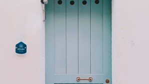 A teal door with a metal handle and a small metal plate above it. - Apartment "Dimora Teatro" with Landmark View & A/C (Alghero)