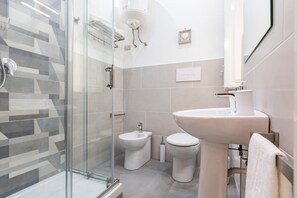 Regadera, secadora de cabello, bidet, toallas