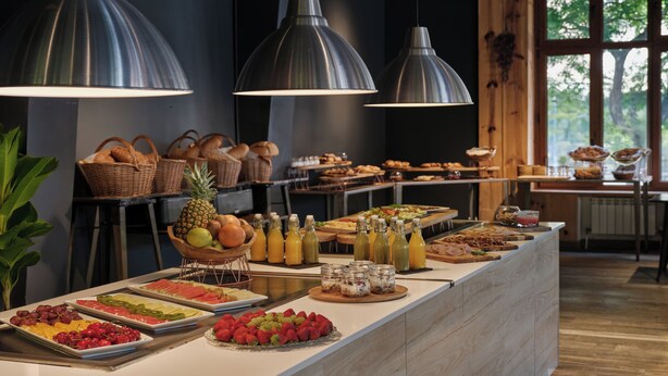 Un buffet proposant une variété de fruits, de pâtisseries et de boissons.