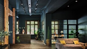 Un hall d’entrée moderne avec un comptoir d’accueil, des éléments décoratifs en bois et de grandes fenêtres.
