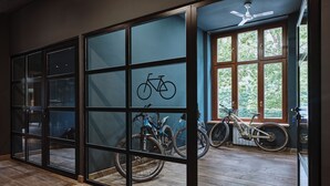 Une pièce dotée d’une grande porte-fenêtre coulissante donnant sur un balcon où se trouvent des vélos.