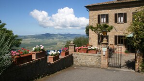 Un edificio de piedra con una pared de piedra y macetas con flores.