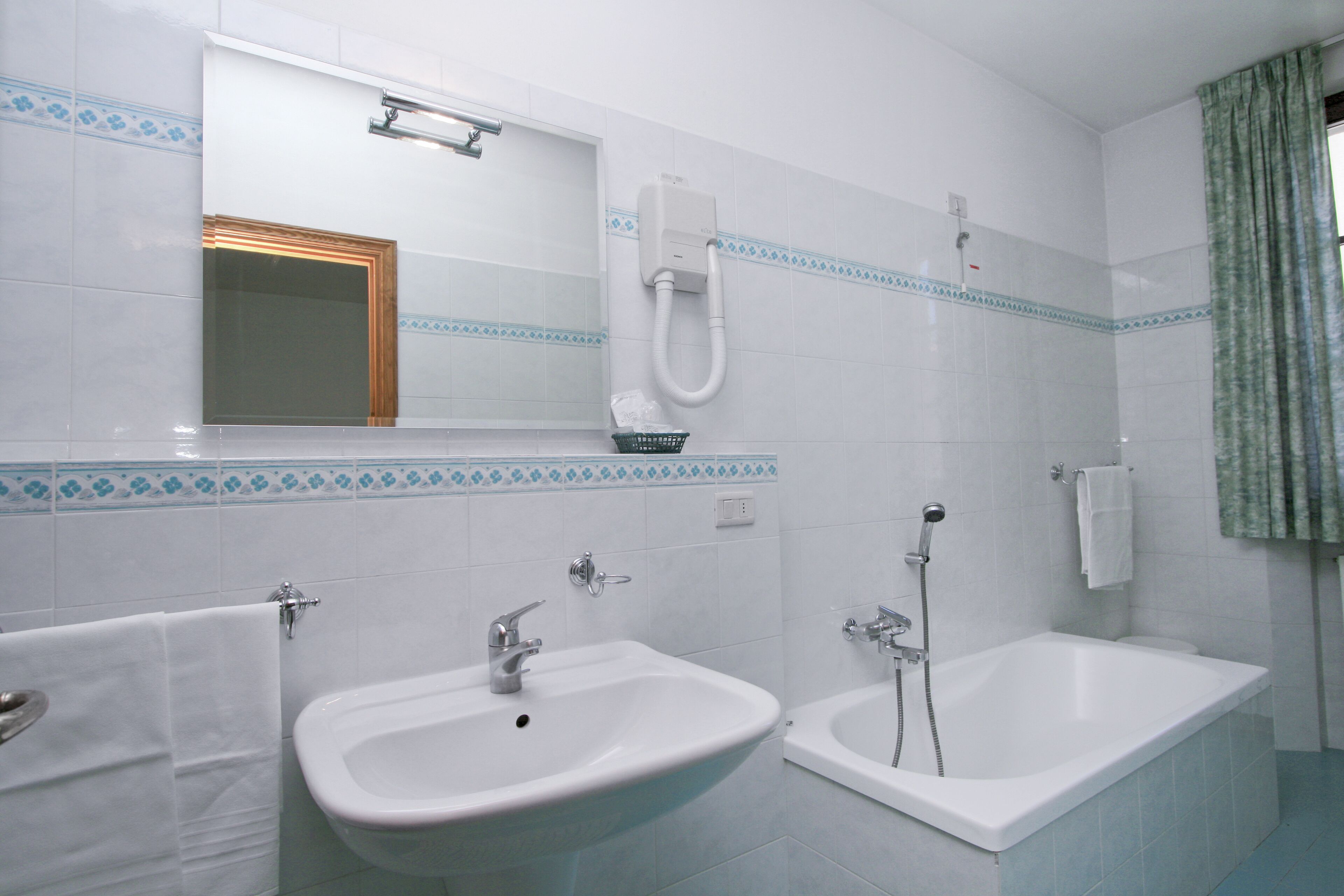 A bathroom with two sinks, a bathtub, and a shower.