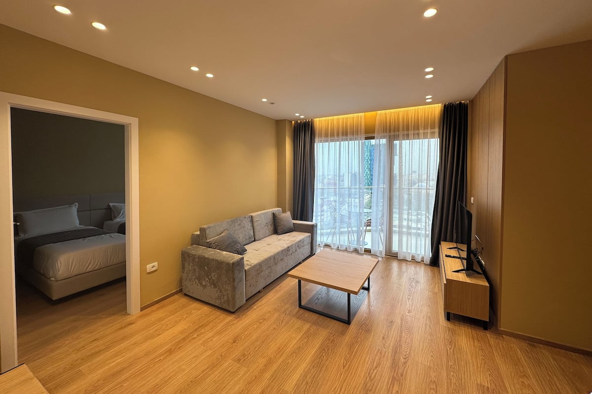 A modern living room with a sofa, a coffee table, and a TV stand.