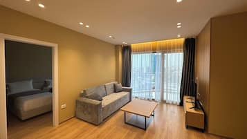 Una sala de estar moderna con un sofá, una mesa de centro y un mueble para televisión.