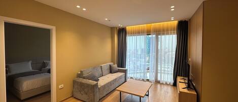 A modern living room with a sofa, a coffee table, and a TV stand.