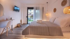 A bedroom with a bed, a desk, a TV, and a balcony with a view. - Alios Gaia (Sithonia)