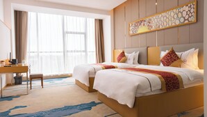 A hotel room with two beds, a desk, and a large window with curtains. - ST Vegas Hotel (Hadxayfong)