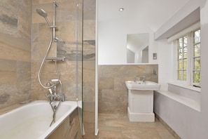 Een bad/douchecombinatie, handdoeken, zeep