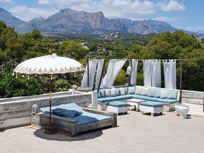 A rooftop terrace with a wooden bed, a sofa, and an umbrella. - luxury apartment Cielo ADULTS ONLY (Altea)