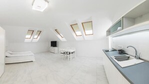 A modern kitchen with skylights, a dining area, and a small seating space.