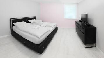 Un dormitorio con una cama, un aparador y un televisor.