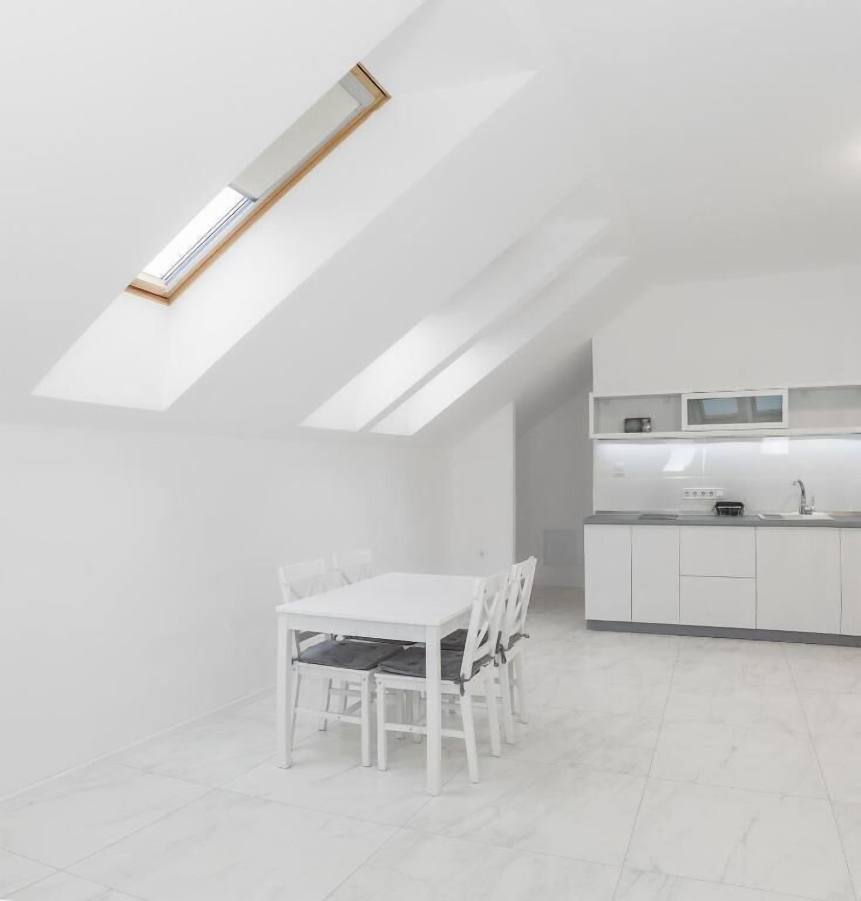 Une cuisine moderne avec des meubles blancs et un petit îlot central.