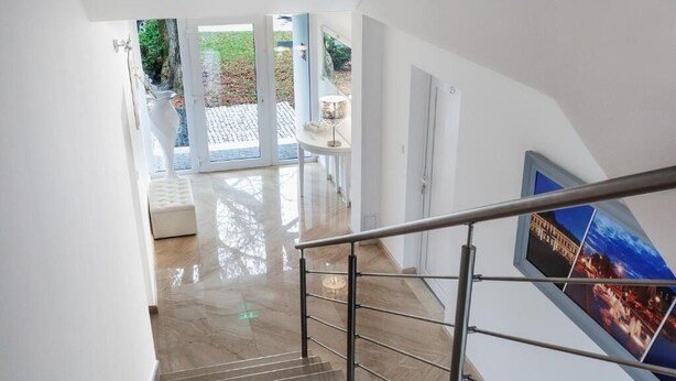 A staircase with a metal railing leading to a door with glass panels.