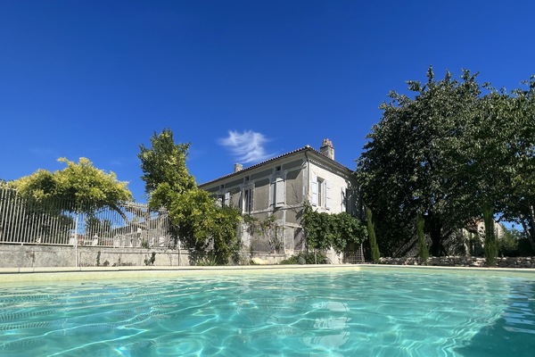 Una piscina al aire libre de temporada, sombrillas
