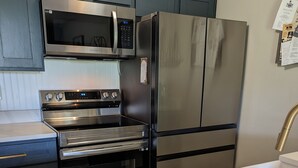 A modern kitchen with stainless steel appliances, including a microwave, oven, and refrigerator. - Ground Floor Waterfront Condo! (Montgomery)