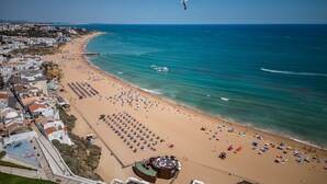 Un hôtel situé sur la côte, avec vue sur la plage, une piscine et un bar.