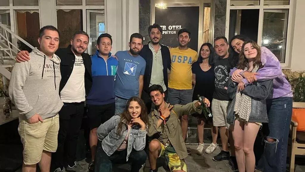 Un grupo de personas posando frente a un edificio con un letrero que dice "HOTEL".