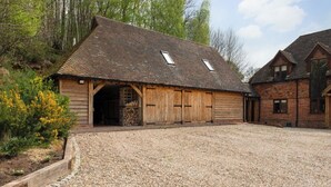 A rustic barn-style building with a gravel driveway and wooden doors. - Stunning Studio, Canterbury (Canterbury)