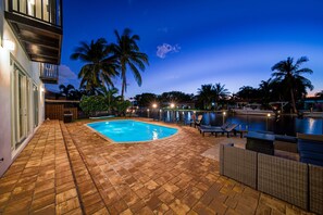 A swimming pool with lounge chairs and a wooden deck.