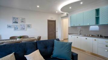 Appartamento Deluxe, vista mare | Area soggiorno | TV a schermo piatto