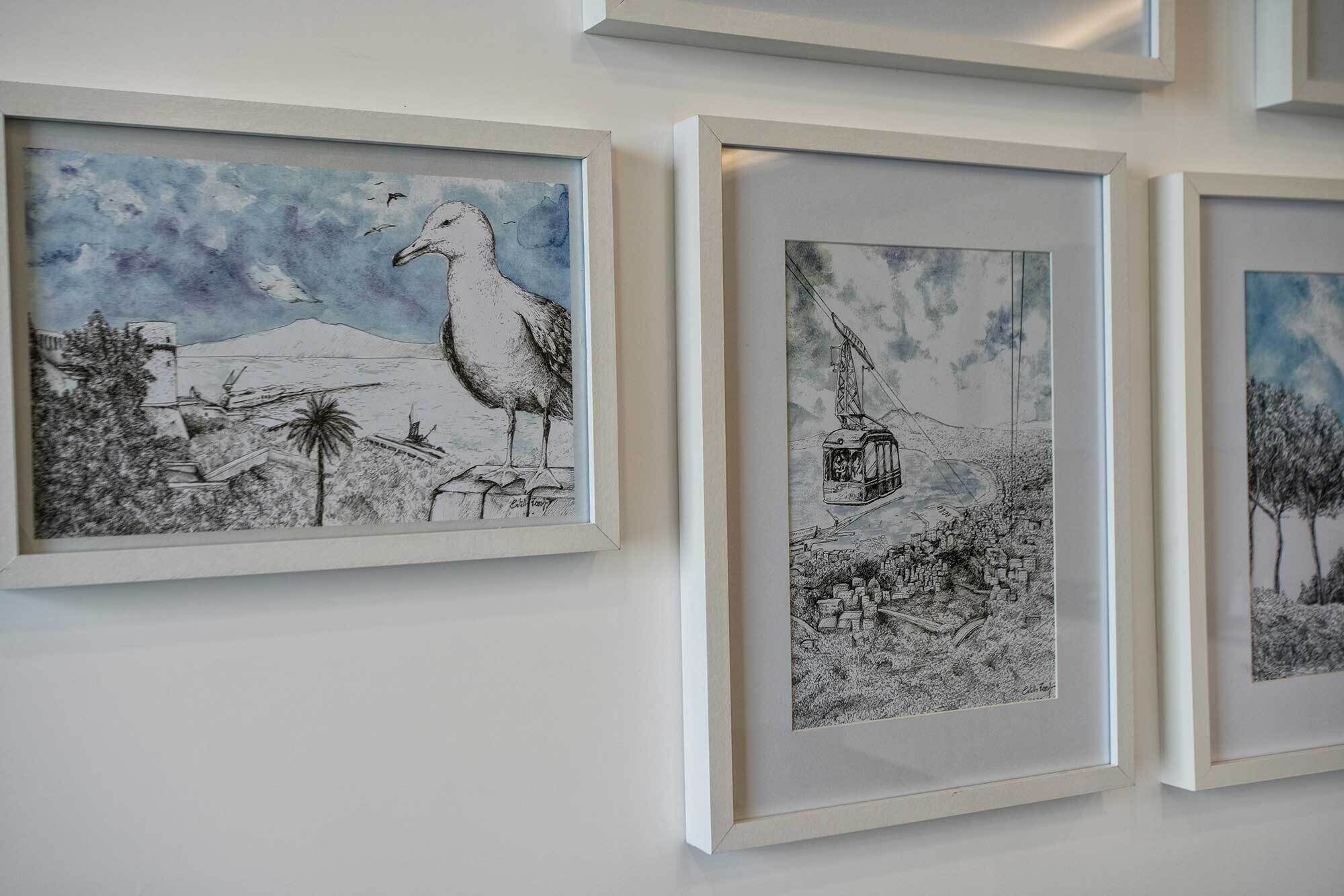 Three framed black and white artworks on a wall.