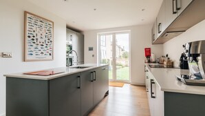 A modern kitchen with a central island, a coffee machine, and a large window. - CH Apt 2 2bed in Bath (Bath)
