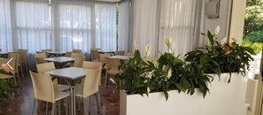 A restaurant with tables and chairs arranged in a spacious indoor area. - Hotel Haiti B&B (Cervia)