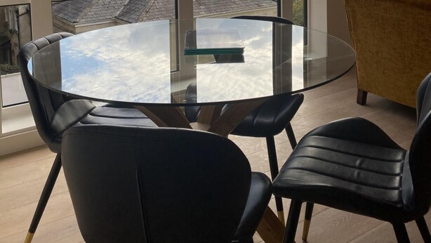 A modern dining area with a glass table and black chairs, large windows offering a view of the cityscape. - CH Apt 5 2bed in Bath (Bath)