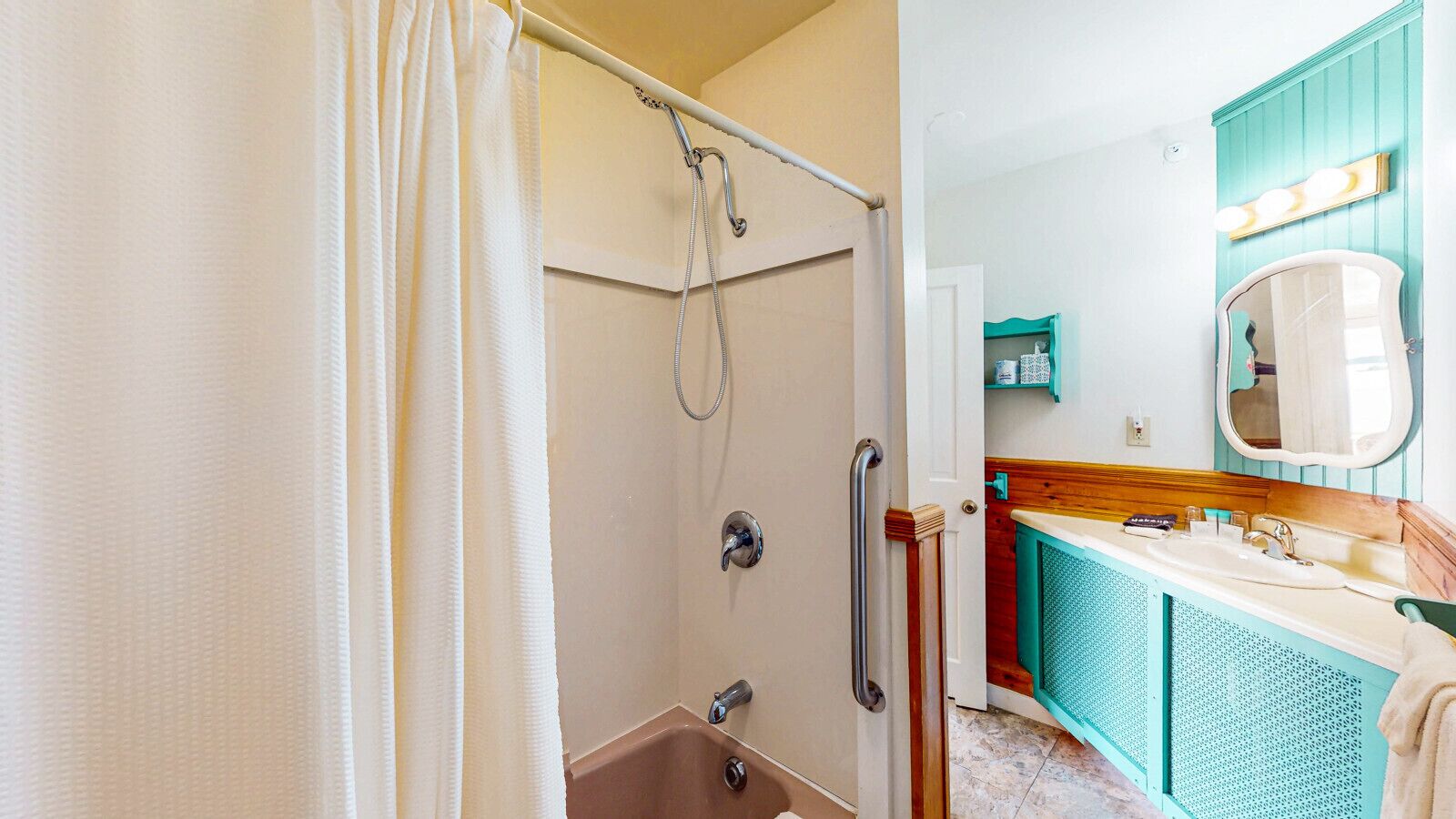 A bathroom with a shower, a sink, and a mirror.