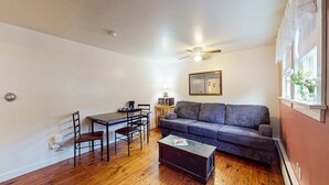 A compact living space with a dining table, chairs, a sofa, and a coffee table.