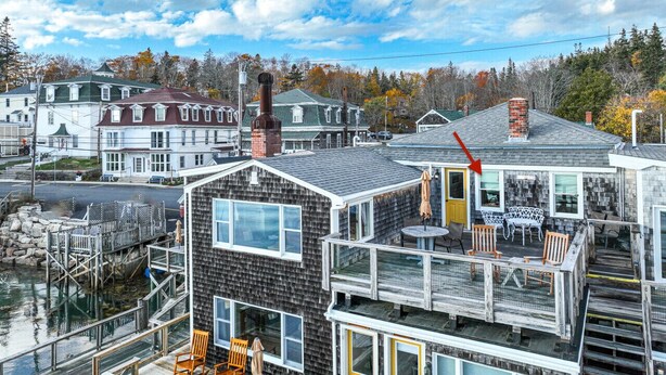A waterfront property with a dock, multiple decks, and a prominent chimney. - The Roseway - Inn on the Harbor (Stonington)