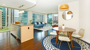 Un apartamento moderno con cocina, sala de estar y comedor, con amplias ventanas y vistas a la ciudad.