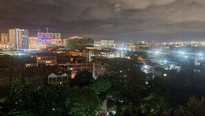 Een verlicht stadsbeeld 's nachts met gebouwen en een hijskraan.