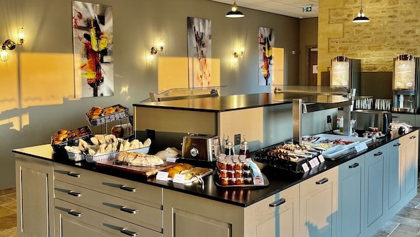 A modern kitchen with a central island, stainless steel appliances, and a variety of food items. - Hotel le Périgord (La Roque-Gageac)