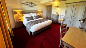 A hotel room with a large bed, bedside tables, a desk, and a chair. - Hotel le Périgord (La Roque-Gageac)