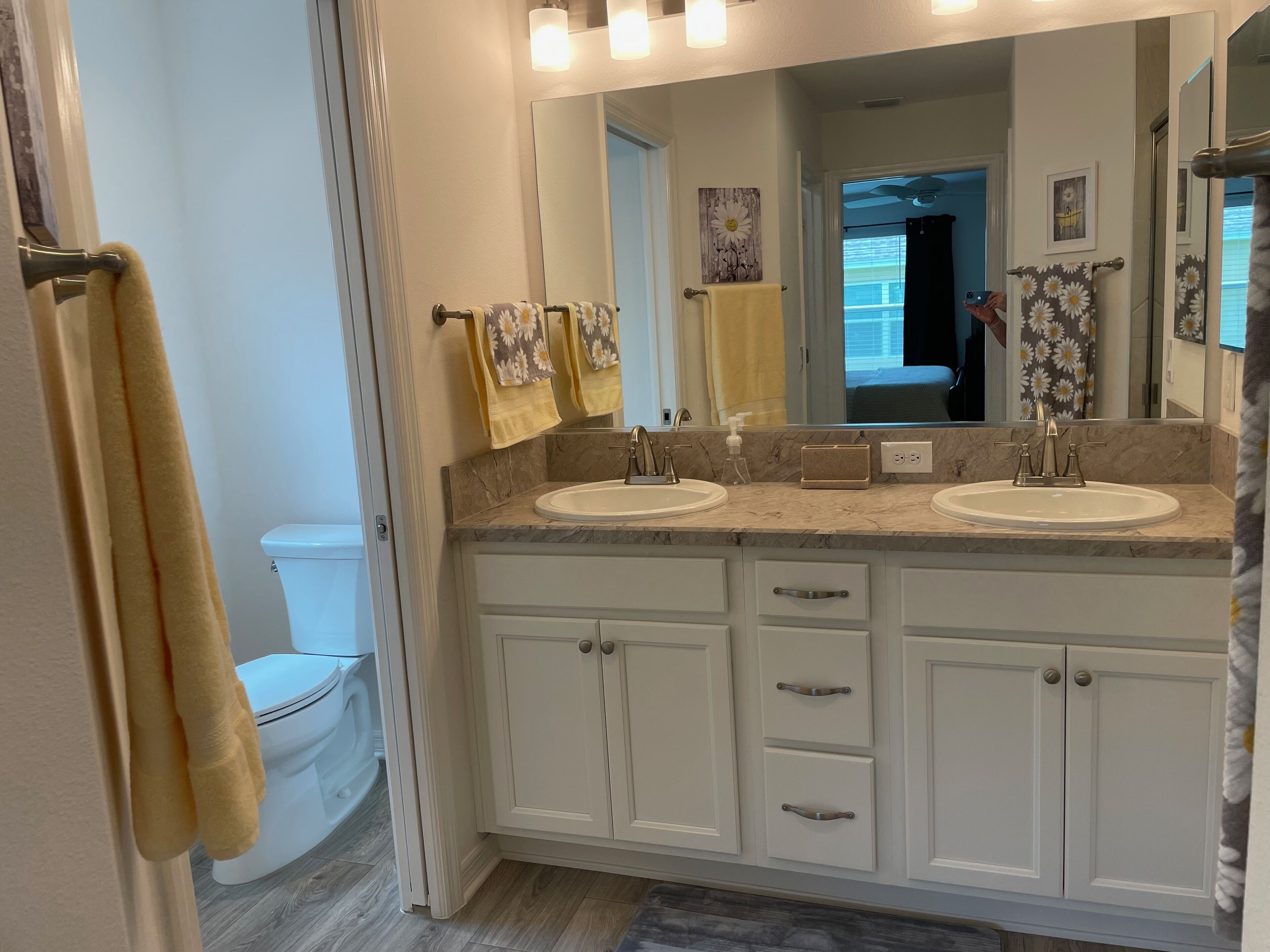 A bathroom with two sinks, a large mirror, and a toilet.