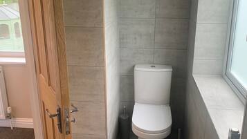Une salle de bain avec des toilettes, un bidet et une fenêtre.